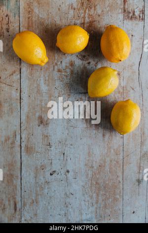 Cinque limoni su sfondo di legno Foto Stock