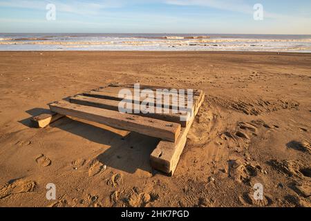 Pesante zattera di legno lavata su una spiaggia Foto Stock