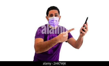 Uomo caucasico femminista che indossa una camicia con segno di genere donna mentre punta la mano allo smartphone con maschera facciale sterile isolato su sfondo bianco st Foto Stock