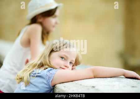 Giovani ragazze che esplorano la famosa città di Pitigliano, situata in cima a una cresta vulcanica di tufo, conosciuta come la piccola Gerusalemme. Belle città e ville italiane Foto Stock