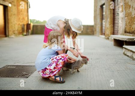 Giovani ragazze che esplorano la famosa città di Pitigliano, situata in cima a una cresta vulcanica di tufo, conosciuta come la piccola Gerusalemme. Belle città e ville italiane Foto Stock