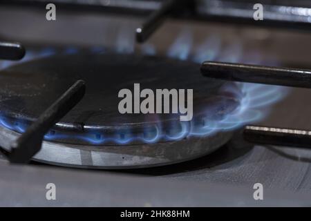 Un anello di gas su un fornello con fiamme crescenti che si innalzano a destra Foto Stock