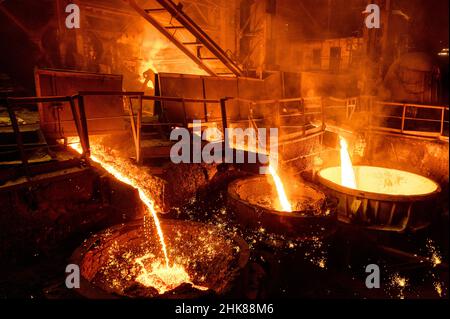 Scorie di altoforno e spillatura di ghisa. Il metallo fuso e la scoria vengono versati in una siviera. Foto Stock