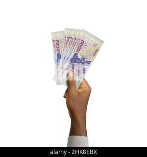 La mano nera che tiene 3D ha reso 10000 note CFA dell'Africa occidentale isolate su sfondo bianco Foto Stock
