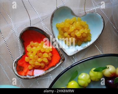 tè tempo primo piano di dessert Thai Deletable frutta imitazione e tuorlo d'uovo d'oro pizzicato impostazione a forma di cuore piccoli piatti colorati San Valentino con amore Foto Stock