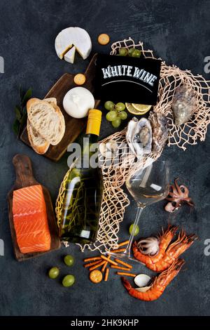 Vino bianco Pinot Grigio con frutti di mare e spuntini. Bevande alcoliche tradizionali. Vista dall'alto, piatto Foto Stock