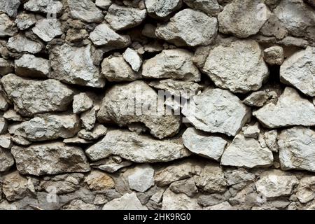 Vecchio muro dilapidato di cabina di pietra grigia, cemento spruzzato in luoghi, ha bisogno di riparazione Foto Stock