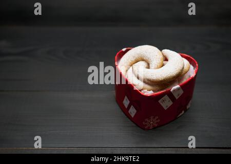 Confezione regalo a forma di cuore piena di biscotti Kipferl alla vaniglia tradizionali tedeschi o austriaci Vanillekipferl Foto Stock