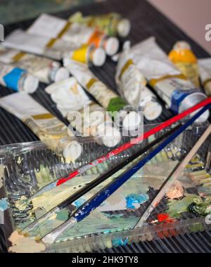 Pitture e pennelli di artista in un laboratorio d'arte Foto Stock