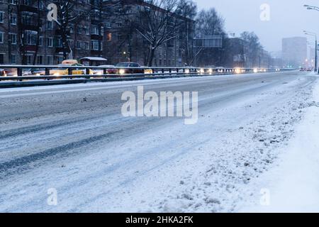 Strada della città vuota coperta di neve in blu crepuscolo invernale nella città di Mosca Foto Stock