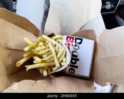 Basilea, Svizzera - 20 dicembre 2021: Immagine verticale delle patatine fritte e delizie Double BigMAC acquistate al ristorante Basel McDonald's. Foto Stock