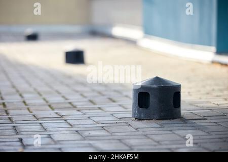 Sistema di ventilazione del tetto ad aria dell'edificio commerciale con camini di plastica uncinata e condotti in fila su tetto in tegole fuoco selettivo Foto Stock