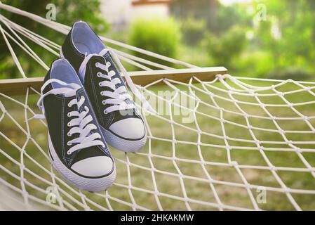 Sneakers all'amaca. Chiiling out in caldo concetto di vacanza estiva. Relax in giardino Foto Stock