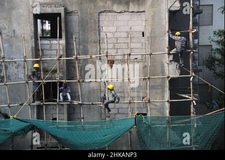 Mumbai, Maharashtra, India- Asia, Nov. 2019 - lavoratori edili indiani che lavorano su un edificio alto senza cintura di sicurezza. Foto Stock