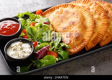 Il Chebureki è un piatto nazionale di cucina Tatar Crimea, con un unico pezzo di pasta rotonda con carne che si riempie da vicino in un piatto sul tavolo. Hor Foto Stock