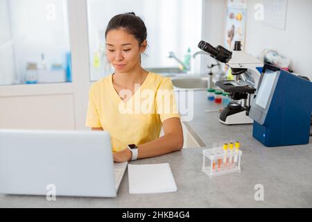 Assistente veterinario femminile utilizzando un computer portatile in laboratorio Foto Stock