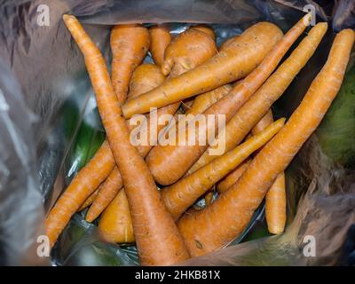 carote in sacchetto di plastica acquistate al mercato tradizionale. L'agricoltura indonesiana raccoglie molte carote Foto Stock