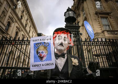 Westminster, Londra, Regno Unito. 03rd Feb 2022. Un manifestante vestito come una versione clown di Charlie Chaplin tiene un segno che dice 'eleggere un clown - Bojo - prevedere un Circus' fuori dalle porte di Downing Street oggi. Credit: Imagplotter/Alamy Live News Foto Stock