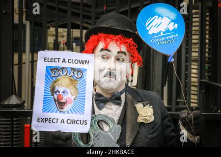 Westminster, Londra, Regno Unito. 03rd Feb 2022. Un manifestante vestito come una versione clown di Charlie Chaplin tiene un segno che dice 'eleggere un clown - Bojo - prevedere un Circus' fuori dalle porte di Downing Street oggi. Credit: Imagplotter/Alamy Live News Foto Stock