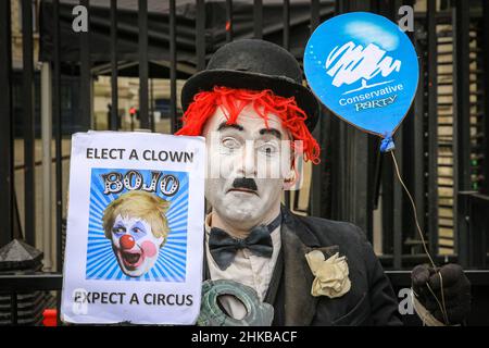 Westminster, Londra, Regno Unito. 03rd Feb 2022. Un manifestante vestito come una versione clown di Charlie Chaplin tiene un segno che dice 'eleggere un clown - Bojo - prevedere un Circus' fuori dalle porte di Downing Street oggi. Credit: Imagplotter/Alamy Live News Foto Stock