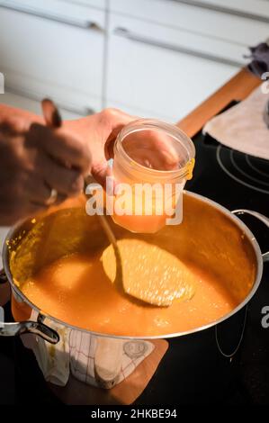 Preparazione a mano di marmellata d'arancia fresca fatta in casa in cucina Foto Stock