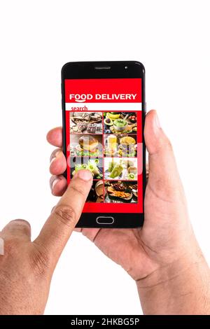 fare clic con la mano sullo schermo del telefono cellulare dello smartphone per ordinare gli alimenti tramite l'app per la consegna degli alimenti Foto Stock