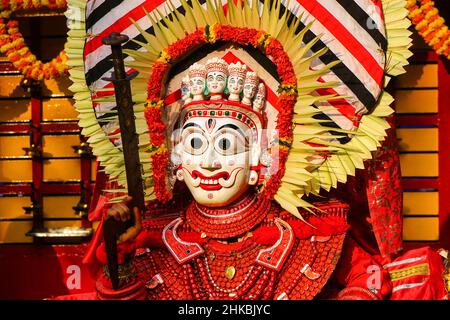 Un artista Theyyam è adornato con costume tradizionale colorato e una maschera prima di una performance al festival di Kannur, Kerala, India. (3) Foto Stock