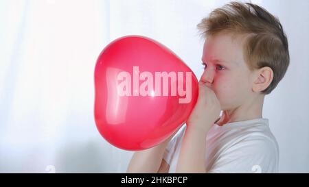 Little Boy si gonfia un palloncino Foto stock - Alamy