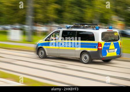 La polizia tedesca auto con lettere Polizei guida veloce su chiamata per strada. Auto della polizia che si precipita su un incidente sulla strada sfocata, 2022 gennaio, Dresda, Germania. Foto Stock