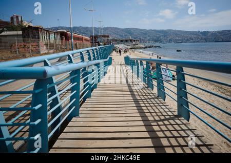 Valparaiso, Cile - Febbraio, 2020: Rampa che porta alla spiaggia di Playa Los Placeres. Vecchie auto della metropolitana abbandonate sulla sinistra. Edificio Tornamesa Foto Stock