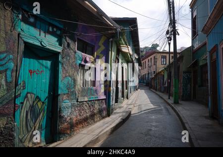Valparaiso, Cile - Febbraio, 2020: Strada vuota a Valparaiso con edifici dipinti da graffiti. Arte di strada a Valparaiso Foto Stock
