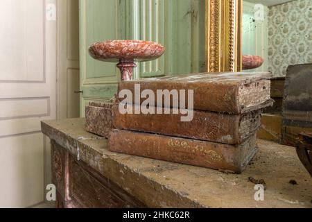 Libri molto vecchi e polverosi si trovano su una sponda di una vecchia casa abbandonata. Foto Stock