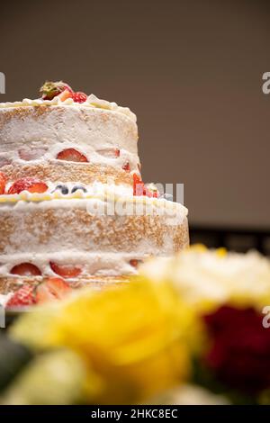 Guardando la torta di nozze attraverso i fiori ... Foto Stock