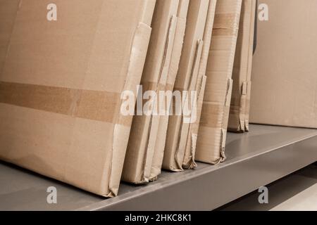 Fornitura di oggetti per materiali da costruzione su scaffali del negozio e di prodotti da costruzione confezionati in cartone. Foto Stock