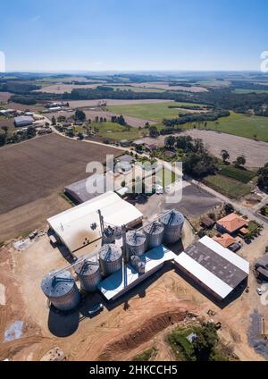 Bella vista aerea drone di silos agricoli per conservare soia e mais in fattoria in Brasile. Concetto di agricoltura, economia, paesaggio rurale. Foto Stock