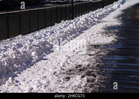 La neve fresca sulla passeggiata in legno in un inverno soleggiato e freddo giorno Foto Stock