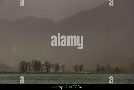 Una giornata di forti piogge a Buttermere, nel Lake District inglese, con le campane circostanti ricoperte di nebbia e nubi basse Foto Stock
