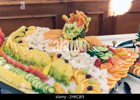 L'esposizione di ananas e agrumi a fette sul tavolo a buffet offre agli ospiti delle feste un dolce piacere. Foto Stock