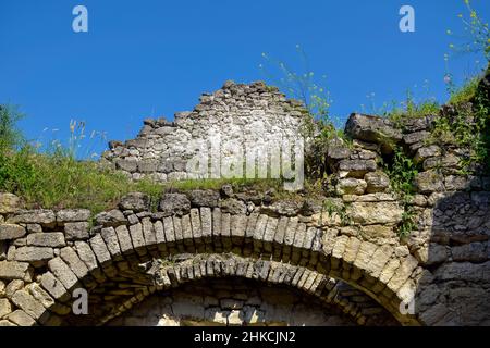 Rovine di un antico tempio cristiano contro il cielo blu. Soffitto crollato. Muratura, sala con volte ad arco. L'erba cresce sulle pareti. Rashkov, Moldavia. Cl Foto Stock