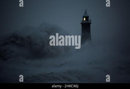 I venti della forza della balla da Storm Arwen causano le onde giganti per battere il faro e il molo nord che sorvegliano la bocca del Tyne a Tynemouth, Inghilterra Foto Stock