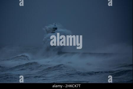 I venti della forza della balla da Storm Arwen causano le onde giganti per battere il faro e il molo nord che sorvegliano la bocca del Tyne a Tynemouth, Inghilterra Foto Stock