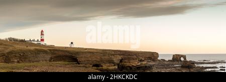 Le strisce rosse e bianche, alte 23 metri, il faro di Souter e i Leas a Marsden, South Shields, Inghilterra, come il sole sorge Foto Stock