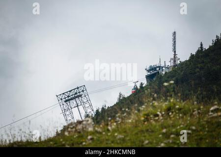 Prati, alberi e una stazione di funivia su una montagna Foto Stock