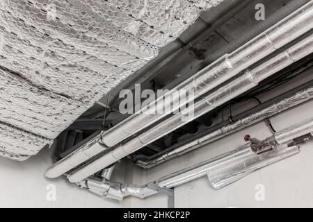 Impianto di climatizzazione per ventilazione in materiale termoisolante condotto tubazioni hvac sul soffitto di un impianto industriale. Foto Stock