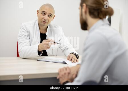 Fisioterapista con un paziente maschile in ufficio Foto Stock