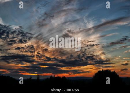 Nuvole scure al Tramonto mentre una tempesta si sviluppa sull'orizzonte. Foto Stock