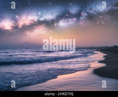 Via Lattea sul mare blu e la spiaggia di sabbia di notte in estate Foto Stock