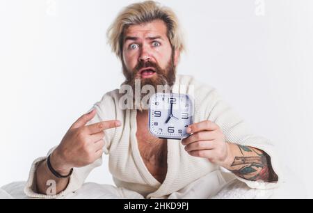 Dormire troppo. Uomo bearded scioccato a letto con sveglia. Tardi per il lavoro, Male mattina, concetto di tardiness Foto Stock