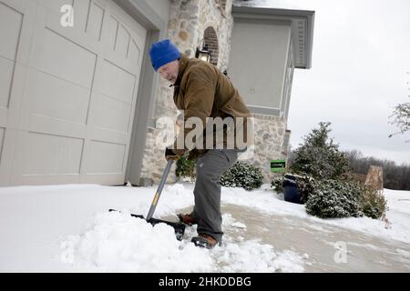 FLOWER MOUND, TEXAS, USA. 3rd Feb 2022. 2/3/22 -FLOWER MOUND, TEXAS - Un fronte freddo colpisce il nord del Texas e il resto del paese, portando pioggia e neve gelide nella regione. Nel 2021, il Texas ha sperimentato una delle peggiori tempeste invernali nella storia che ha portato alla rete elettrica dello stato di spegnere il potere a migliaia di residenti; con questo fresco nella mente dei texani, la gente si prepara per il peggior.This Giovedi, 02/03/2022, Un residente del Texas, Craig, 63, pala neve con i suoi vicini pala da neve. Craig mi dice che ricorda i giorni in cui lo fa quando era più giovane, mentre viveva nel Nort Foto Stock