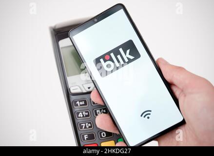 Wroclaw, Polonia - Nov 06, 2019: uomo tenendo lo smartphone con il logo Blik, il pagamento senza contatto. Blik è polacco più popolari di pagamento rapido metodo in Polonia Foto Stock